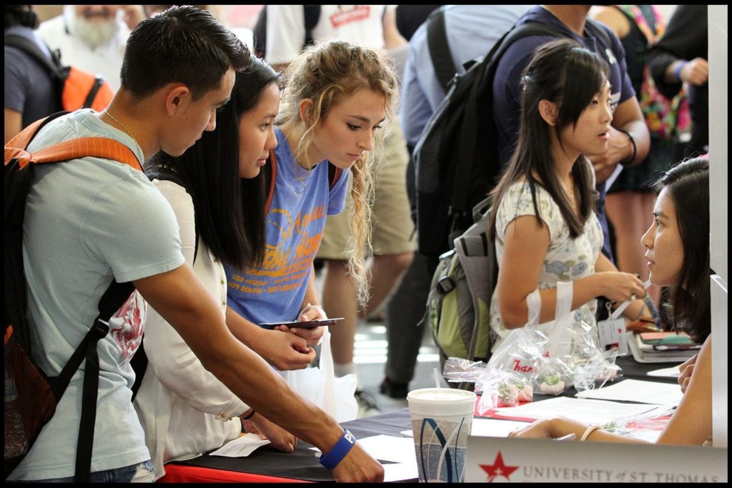 Students at a University St. Thomas booth at a college fair.