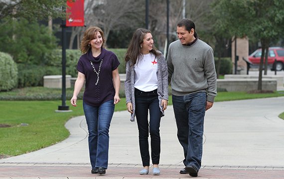 A University of St. Thomas – Houston student and her parents walk through the UST campus
