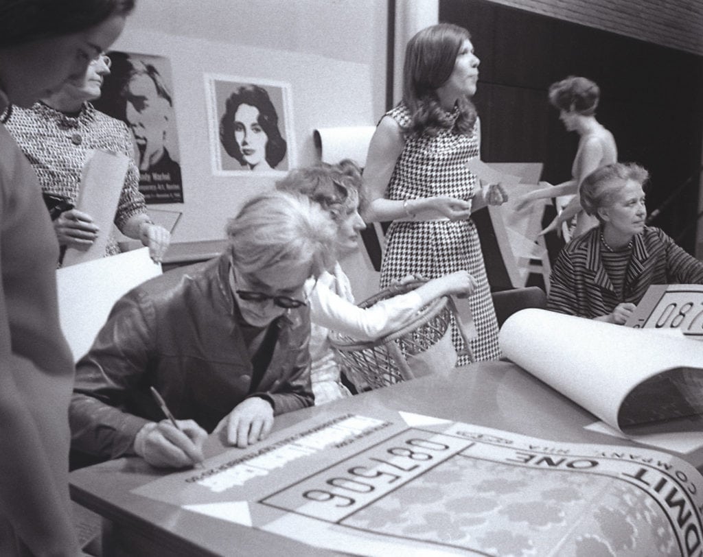 Andy Warhol signing posters.